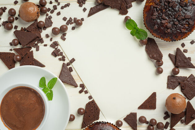 石板白色木质表面的巧克力松饼世界巧克力日概念纸杯蛋糕粉糖果