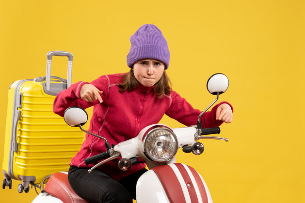 汽车前视图骑着轻便摩托车的年轻女子指着她的轻便摩托车前面轻便摩托车摩托车