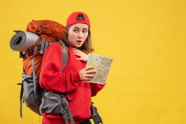 背包前视图好奇的女徒步旅行者与红色背包举行地图正面地图女士