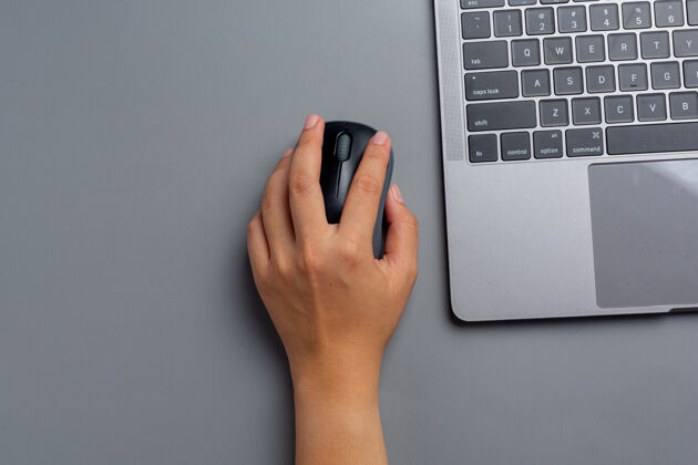 国际女人在家里用笔记本电脑工作 左手拿着电脑鼠标日历通知信息