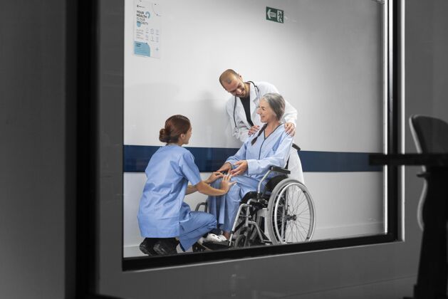 工作医生和护士在轮椅上帮助病人医生激情护士