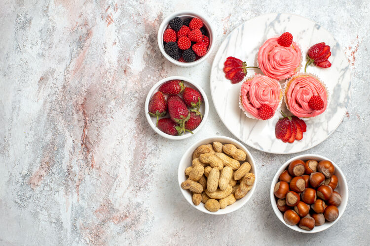 一餐白色表面有坚果的粉色草莓蛋糕俯视图晚餐饮食坚果
