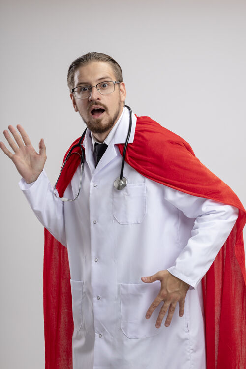 眼镜一个年轻的超级英雄穿着医用长袍 戴着听诊器和隔离在白色表面的眼镜长袍小伙子医疗