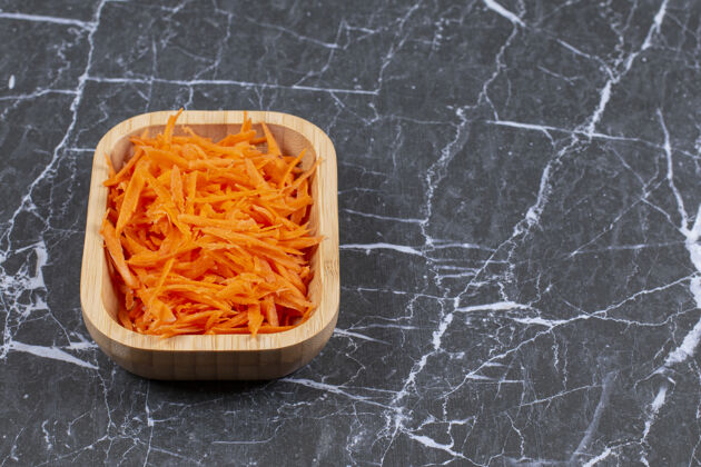 有机棕色木碗中磨碎的新鲜胡萝卜的特写照片碗沙拉自然