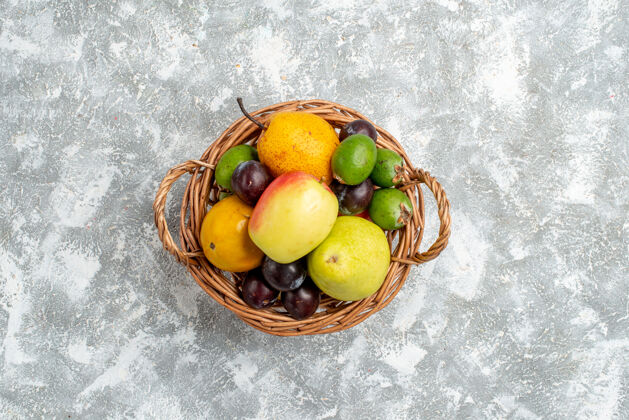 水果在灰色的桌子中央 放着苹果 梨 白杨 李子和柿子的塑料柳条篮子灰色遥远中心