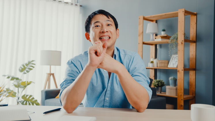 技术年轻的亚洲商人在家工作时用笔记本电脑在视频电话会议上和同事谈论计划咨询老师流行病