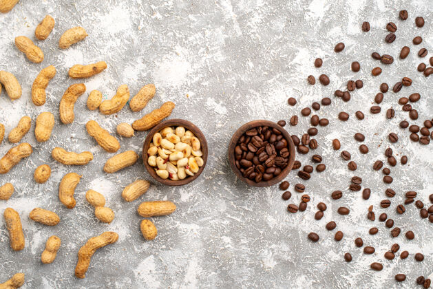 零食白色表面上有棕色咖啡籽的美味花生俯视图种子质地早餐