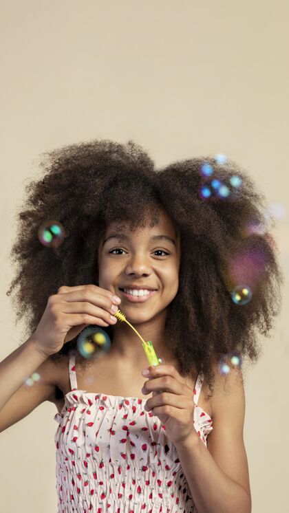 天真年轻可爱的女孩在玩肥皂泡时摆姿势的画像年轻可爱非洲