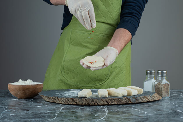 面包师男性手戴手套在大理石桌上做食物烹饪厨师烘焙