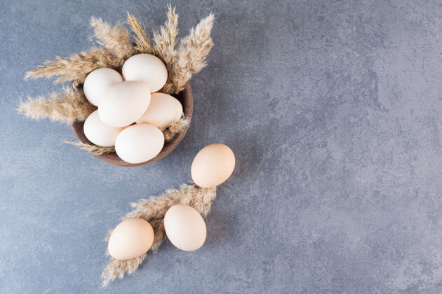 生新鲜的生鸡蛋放在木碗里生的白鸟
