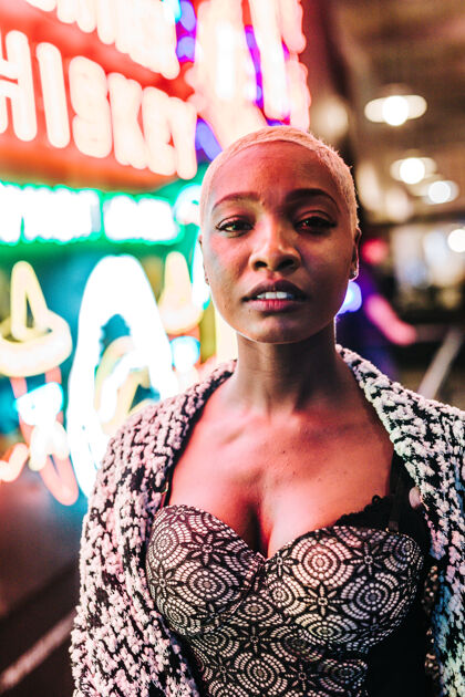 黑发一个美丽的非洲女性站在霓虹灯附近的垂直镜头漂亮文胸模特