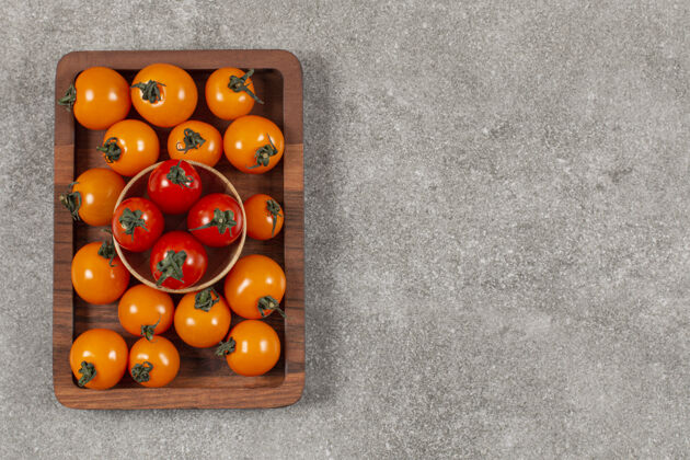食物一堆红黄相间的西红柿放在木板上美味生的番茄