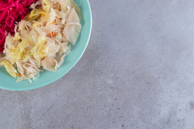 美食蓝盘子的白菜泡菜品种放在石桌上罐头沙拉保存
