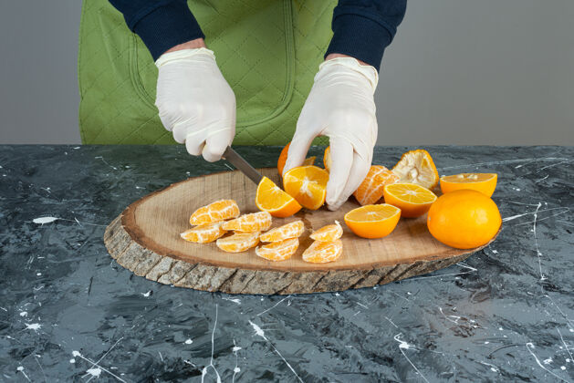 男男人的手在大理石桌上切新鲜的柠檬准备橘子厨师