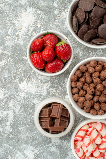 新鲜上半部分的观点与糖果草莓巧克力谷类食品和可可在灰白的地面右侧碗水果可食用水果饮食