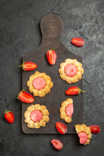 奶油灰色表面上草莓奶油小甜饼的俯视图饼干糖蔬菜