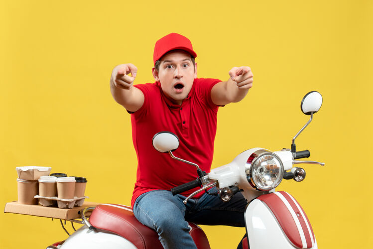 摩托车顶视图是穿着红色上衣 戴着帽子的年轻人在黄色的墙上向前传递命令球交付指向