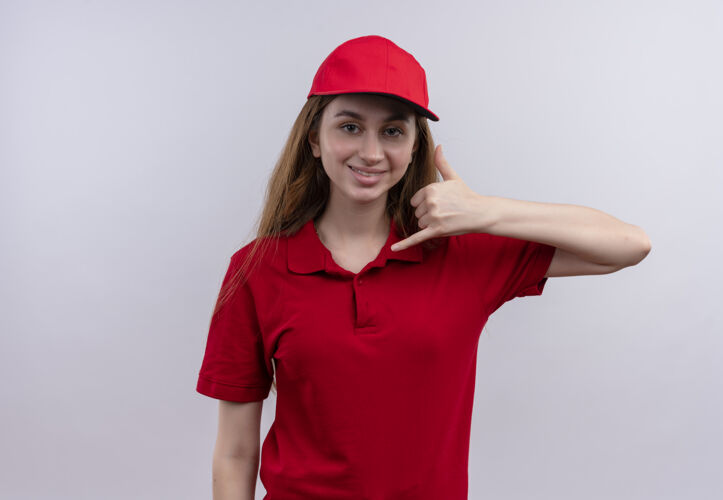 传递带着微笑的年轻送货员穿着红色制服在空白处做着呼叫手势呼叫复制年轻