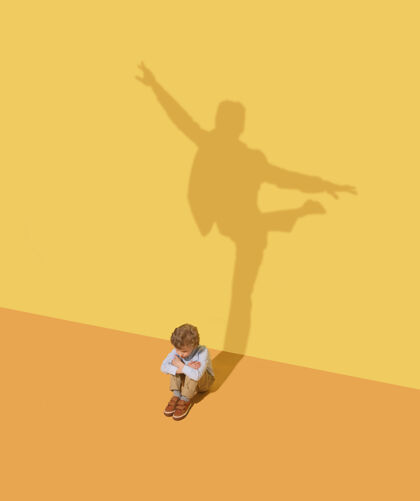 目标灵活性童年和梦想的概念概念形象与儿童和阴影在黄色的工作室墙上小男孩想成为芭蕾舞演员 艺术家在剧院或商人 办公室的人事业表演幻想