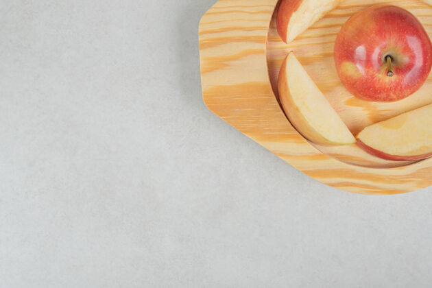 美味把一整片红苹果放在木盘上剁碎苹果食品