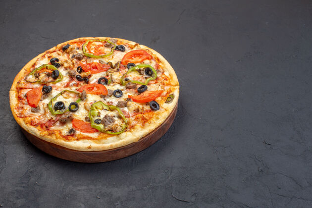 汉堡正面图美味的芝士比萨饼由橄榄 胡椒和西红柿在黑暗的表面组成晚餐奶酪番茄