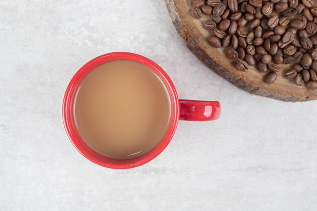 咖啡木片上的咖啡豆配上一杯红色的咖啡香气美味
