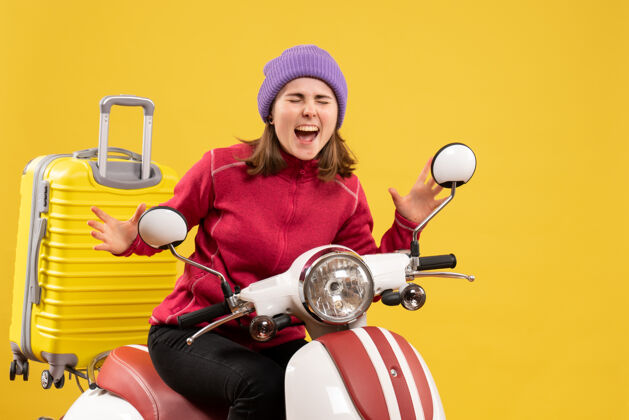 轻便摩托车正面图：一个戴着紫色帽子的小女孩坐在轻便摩托车上表达她的感受快乐感觉帽子