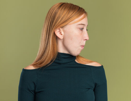 年轻印象深刻的年轻红发姜女孩雀斑看一边橄榄绿壁板雀斑红发