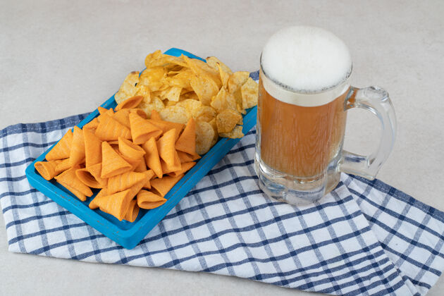 刷新餐盘和一杯啤酒放在桌布上桌布各种膳食