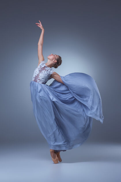 飞行美丽的芭蕾舞演员在蓝色背景上穿着蓝色长裙跳舞别致丝绸当代芭蕾舞