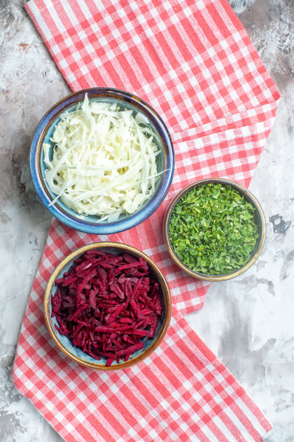 胡椒粉白色表面上的甜菜和绿色切片卷心菜俯视图健康食物切片白菜