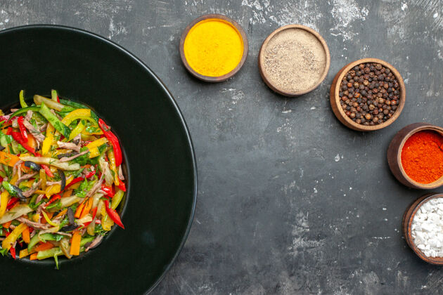 盘子黑色表面上美味蔬菜沙拉的俯视图餐厅厨具菜肴