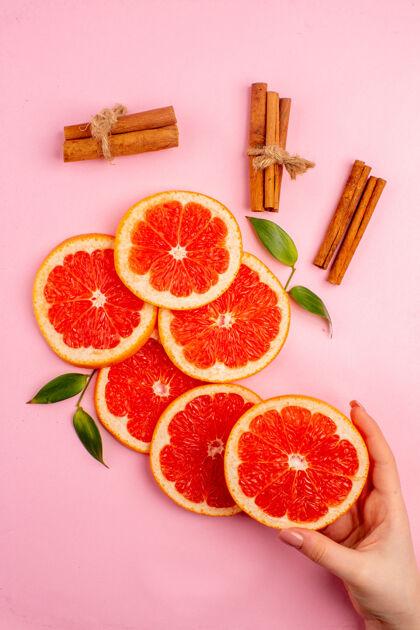 切片美味的葡萄柚和肉桂的粉红色表面多汁水果片俯视图水果健康柚子