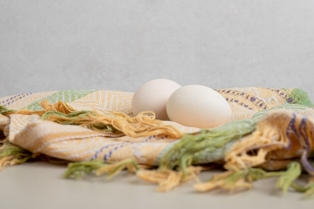 鸡蛋两个新鲜的鸡蛋放在桌布上鸡肉未经料理的未煮熟的