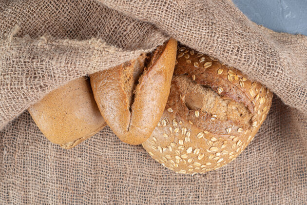 面包房大理石桌上放着一捆面包 上面铺着一块布面包面团卡路里