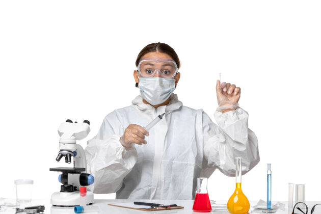 男性前视图身穿防护服 戴着口罩的女医生正在注射白色背景病毒药物covid大流行面具女医生实验室