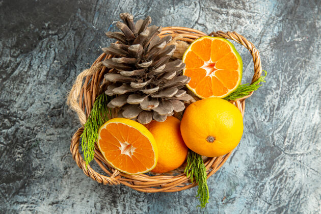 柑橘浅灰色表面上篮子里多汁新鲜橘子的俯视图农产品脐橙甜橙