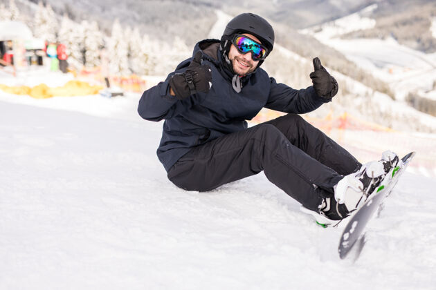 高山滑雪板运动员坐在高高的山坡边的山上 骑前看摄像机高寒冷极限