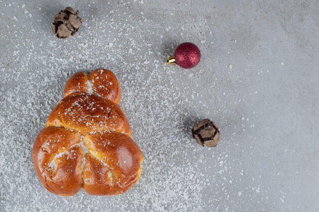 球圣诞和松子球围绕着大理石桌上的甜面包美味圣诞饰品美味