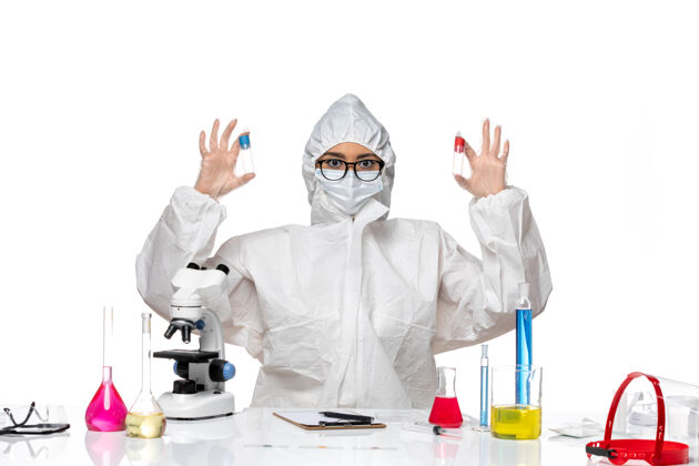 健康正面图穿着特殊防护服的女化学家拿着空瓶子在白色办公桌上病毒健康化学冠状病毒烧瓶工作化学