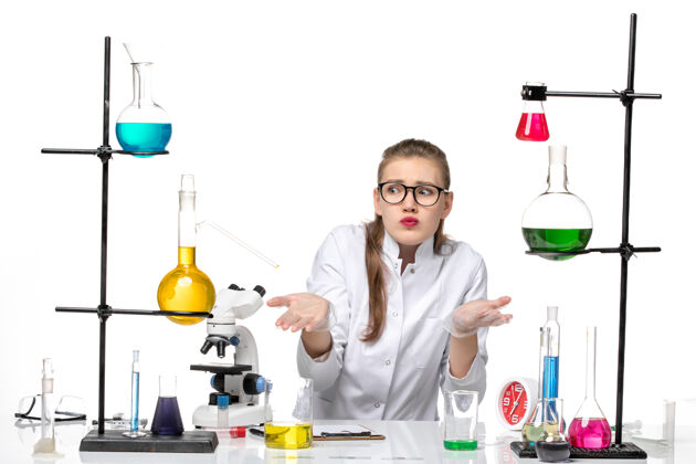 女化学家前视图穿着医疗服的女化学家坐在白色背景上 拿着溶液大流行化学冠状病毒医生困惑前面