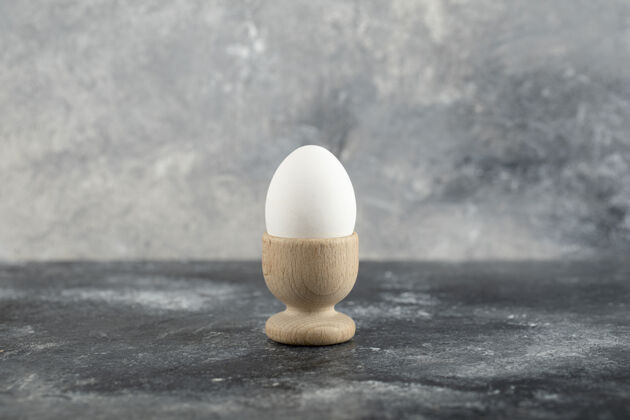 膳食一个木制的鸡蛋杯 里面有煮熟的鸡蛋动物贝壳饮食