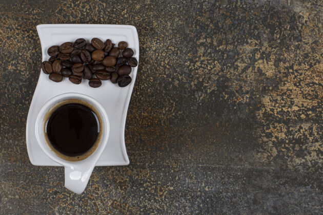 美味浓缩咖啡加咖啡豆放在白色碟子上热的香味咖啡豆