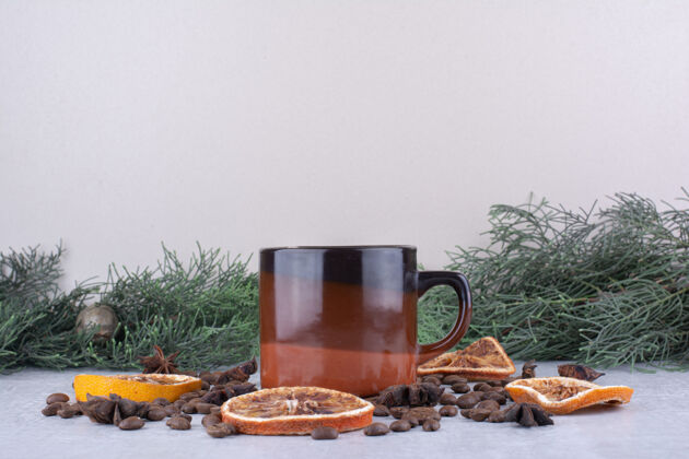 橙子一杯茶 上面放着桔子片和咖啡豆松树美味树枝