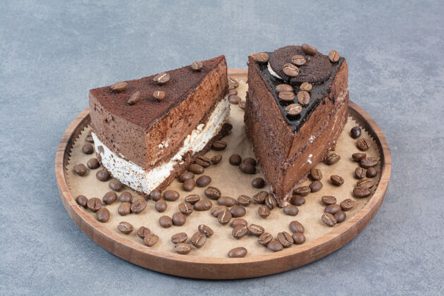 谷物两块香甜可口的蛋糕 木板上放着咖啡豆蛋糕馅饼木头