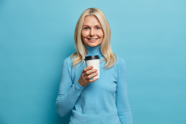 女人漂亮的成年欧洲女人的肖像手持一次性咖啡杯表情脸一次性