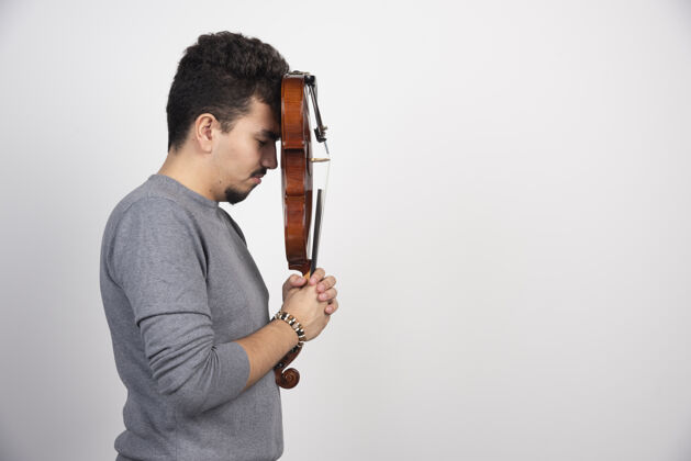 姿势一个音乐家拿着他的棕色木制小提琴 看起来很紧张紧张失望表演