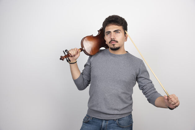独奏音乐家拿着小提琴 想着下一首要演奏的曲子男人姿势聪明