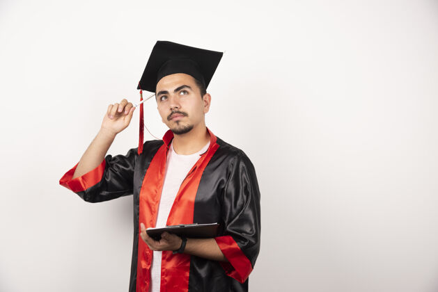 表达年轻的研究生拿着毕业证思考着白色长袍帽子持有