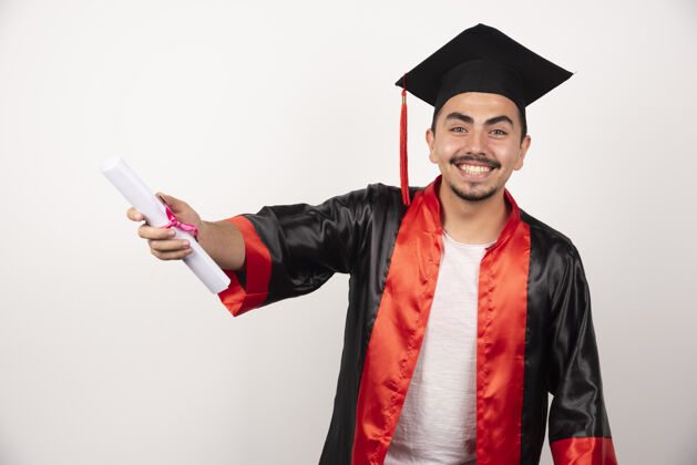 成就毕业证书在白色床上摆姿势证书学生帽子